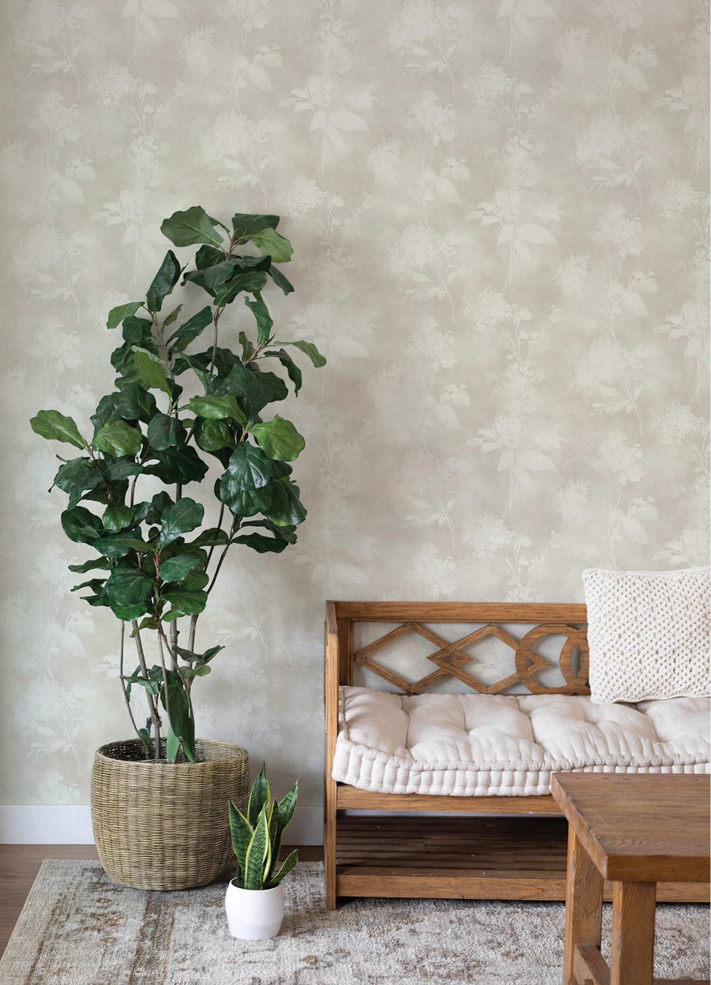 Living room with a wooden bench, table, and potted plants against a textured wall.