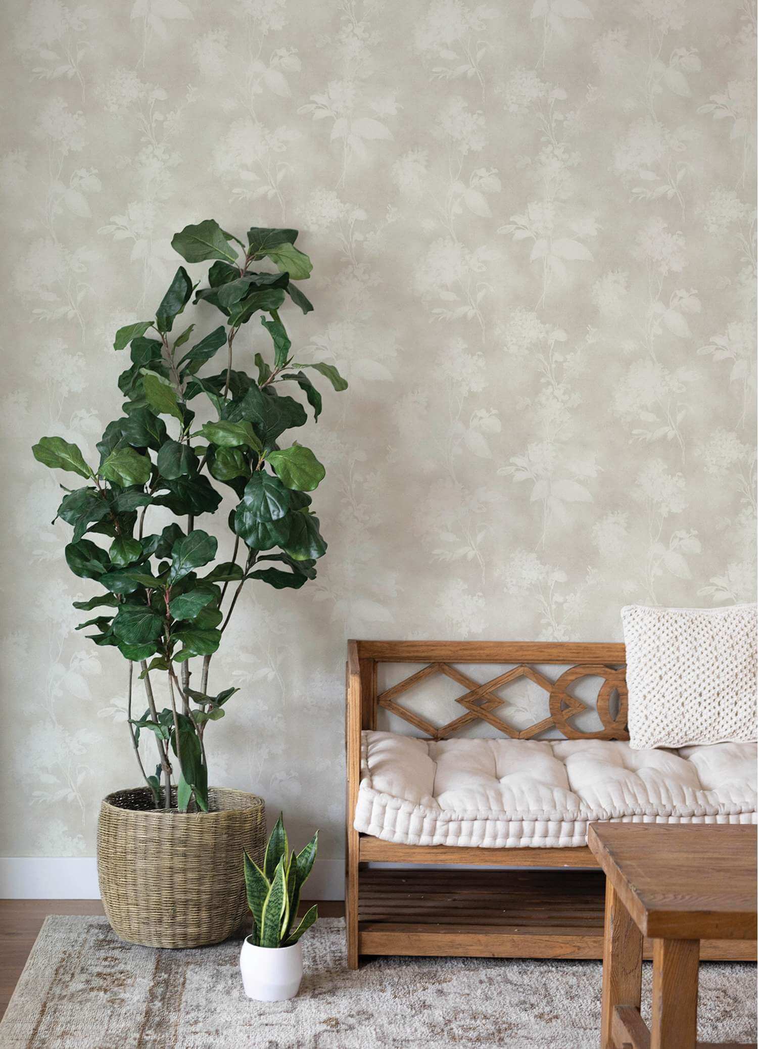 Living room with a wooden bench, table, and potted plants against a textured wall.