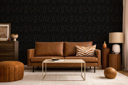 Brown leather sofa with a coffee table in a room with dark textured wallpaper.